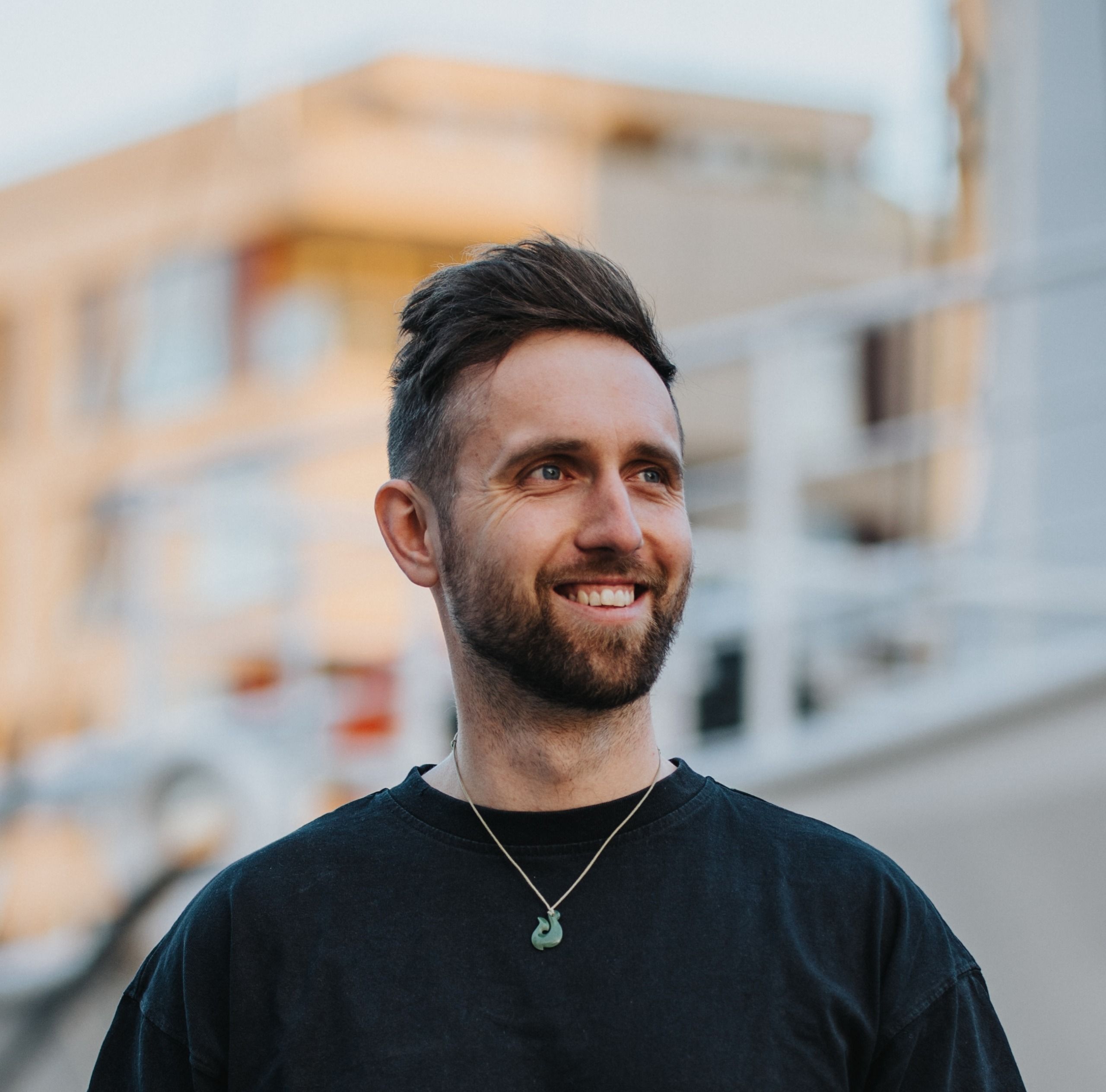 Felix smiling outdoors in a black shirt
